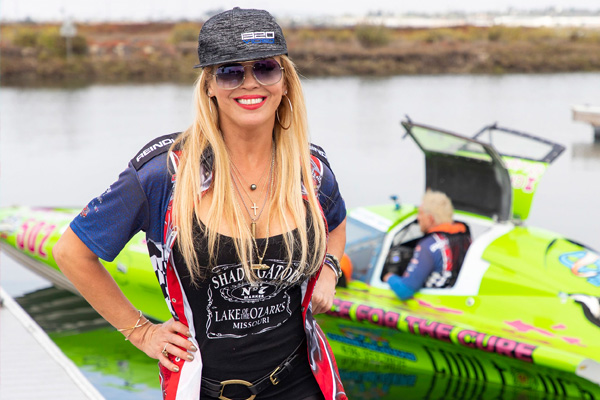Leigh Ann Bauman posing in front of a powerboat. Courtesy Erick Bryner; Fast Loud Photography