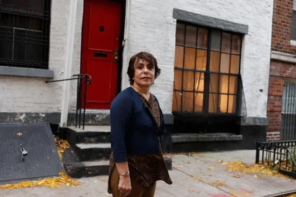 Pari Dulac standing on the sidewalk outside of one of the buldings she owns. Photo credit Angel Chevrestt