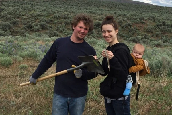 Jake and Jamie Hyland with their 1-year-old son Uriel pose for a photo on rugged terrain. Photo credit GoFundMe/courtesy Tammie Mabry